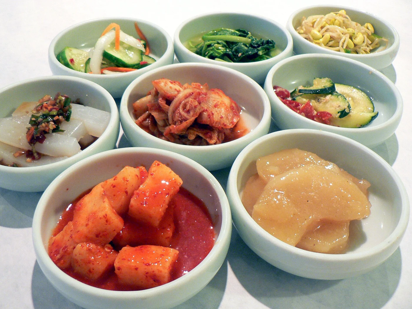 Bowls of kimchi and different vegetable dishes arranged together