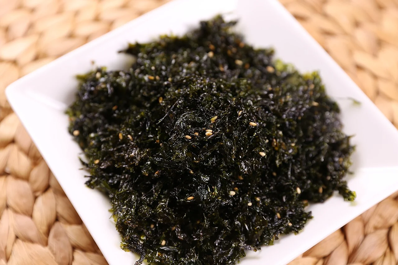 Seaweed flakes and sesame seeds on a white plate
