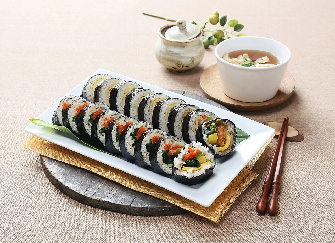 Gimbap slices on a plate with soup alongside