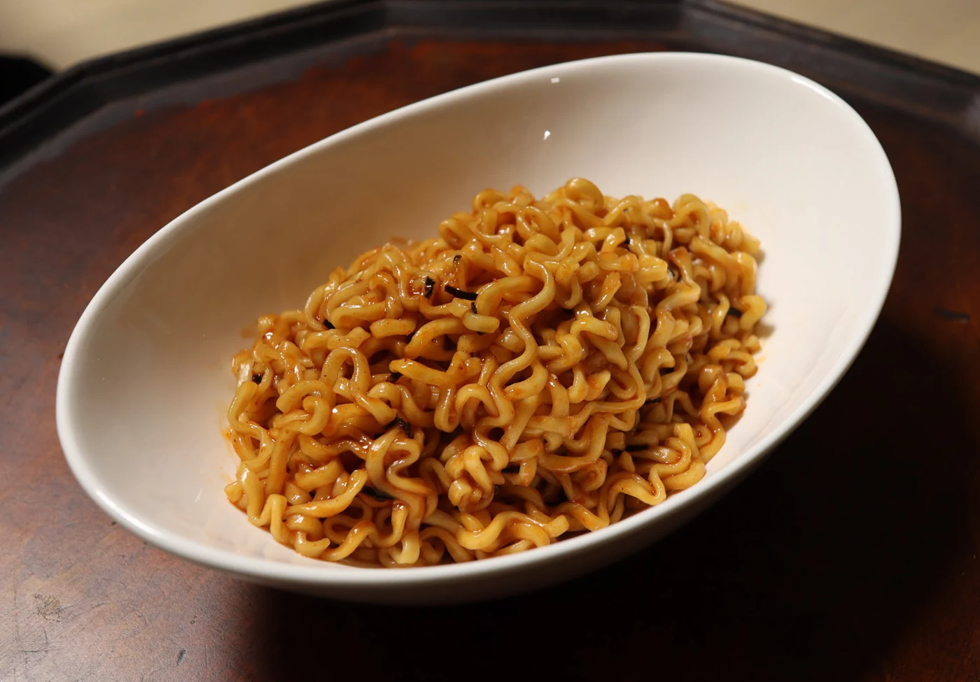 Sauced Buldak noodles in a white oval bowl