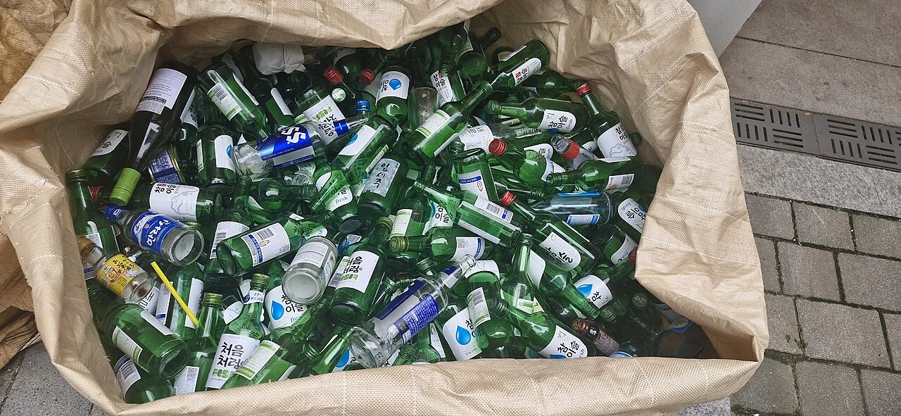 Empty soju bottles and cans gathered in a large collection sack